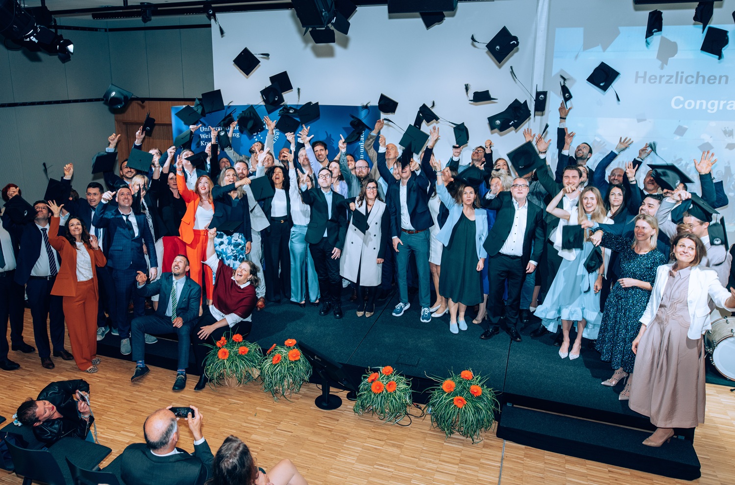 Die Absolventen der Graduierungsfeier 2025 in Krems werfen Ihre Hüte und feiern Ihren Abschluss